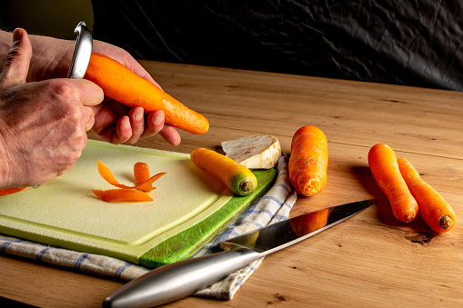 peeling carrots on a green cutting board
