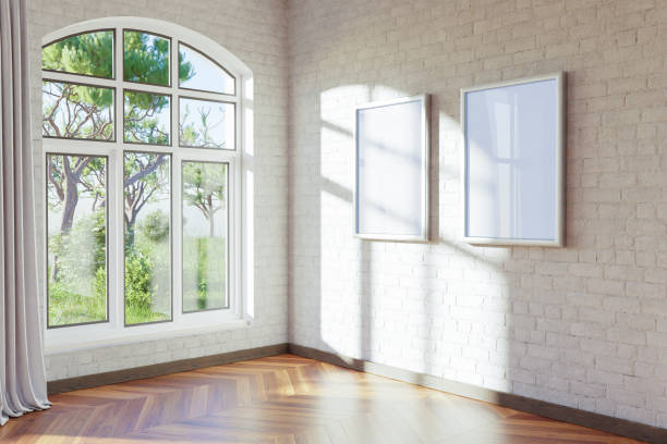 istock empty canvas poster mock up hanging on a wall; empty living room interior; bright daylight shining through a large window; home decoration desing; 3D Illustration 1473052652