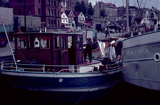 Hamburg, Germany, 1958. Crewed barges in the port of Hamburg. Also: buildings, vehicles and hamburgers.