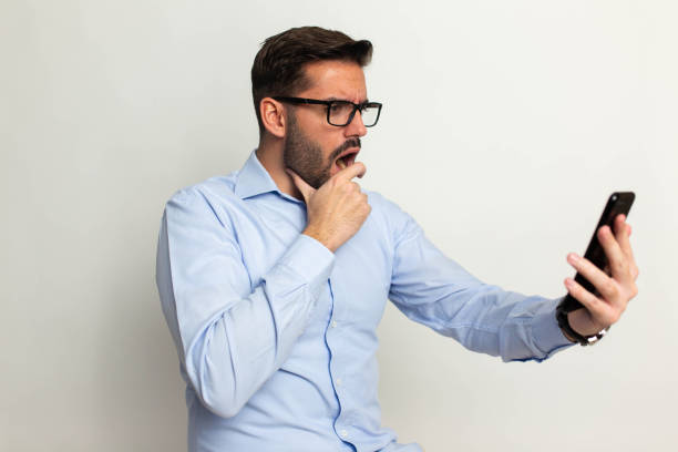 istock Handsome man with mobile phone on gray background 1473057063