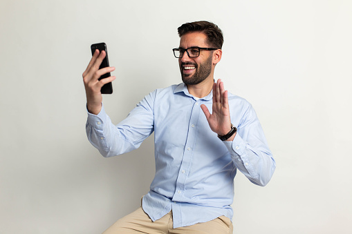 Handsome man with mobile phone on gray background