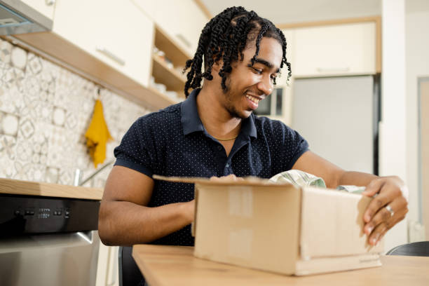 istock Young man is opening a package from the courier service 1473060675