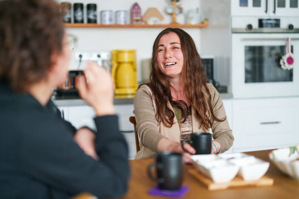 istock Two female friends talking on kitchen table with coffee cup 1473061211