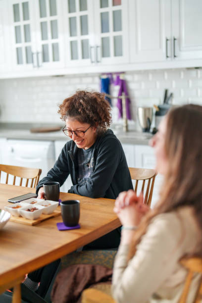istock Two female friends talking on kitchen table with coffee cup 1473061322
