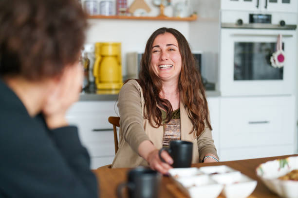 istock Two female friends talking on kitchen table with coffee cup 1473061366