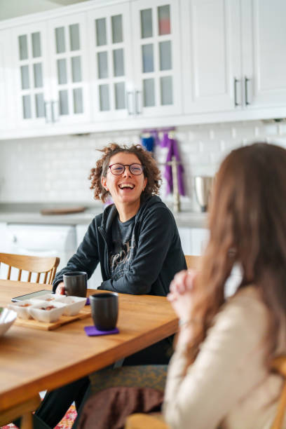 istock Two female friends talking on kitchen table with coffee cup 1473061369