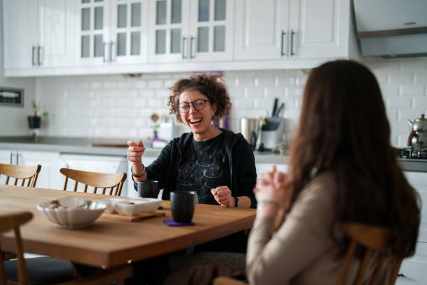 istock Two female friends talking on kitchen table with coffee cup 1473062012