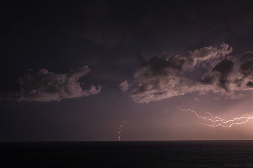 Extreme storm over the ocean with rain, lightning and dark dramatic sky, clouds. Extreme weather scene in Australia.
