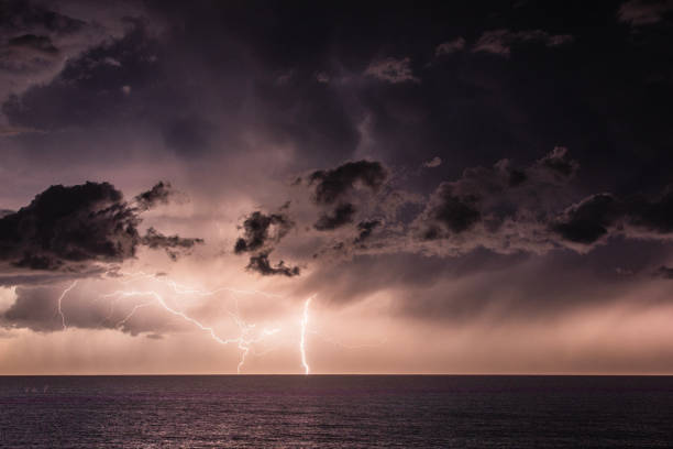 tempesta estrema sull'oceano con pioggia, fulmini e cielo scuro drammatico, nuvole - ocean scenic flash foto e immagini stock