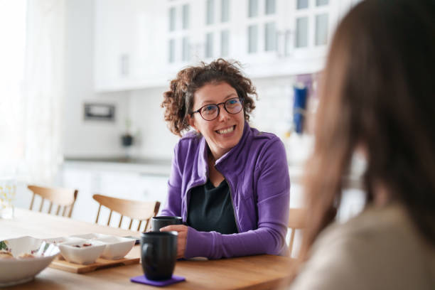 istock Two female friends talking on kitchen table with coffee cup 1473062230