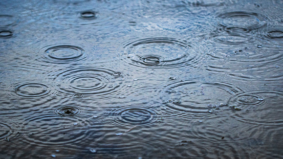 Water droplets creating a natural pattern in a lake during a rain storm. Weather scene.