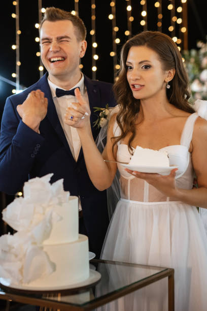 istock newlyweds happily cut and taste the wedding cake 1473063426