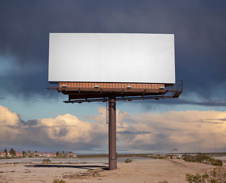 Large blank billboard with desert storm sky.