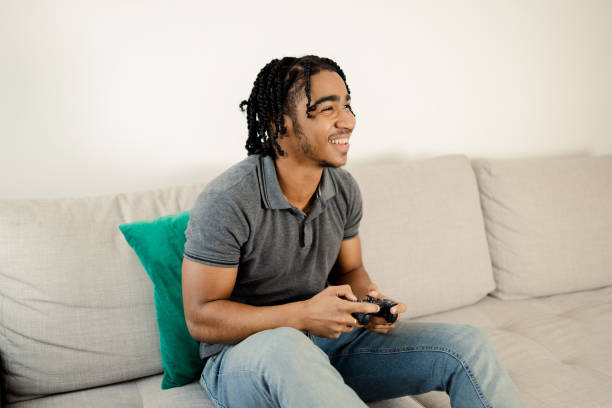 istock Young man gaming and having fun at home 1473065154