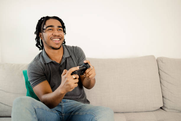 istock Young man gaming and having fun at home 1473065158