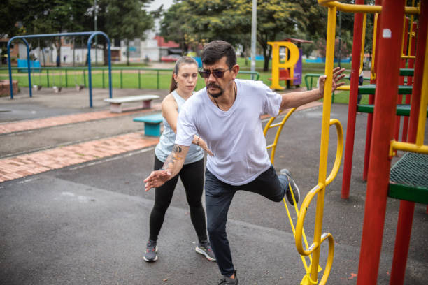 istock Mature man training with help of the his coach on a public park 1473066569