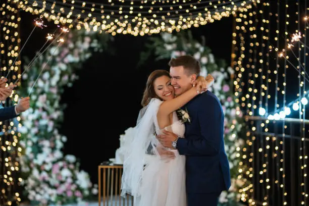 Photo of newlyweds happily cut and taste the wedding cake