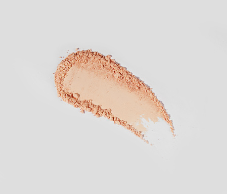 Brush strokes of crushed light beige and brown eye shadow
