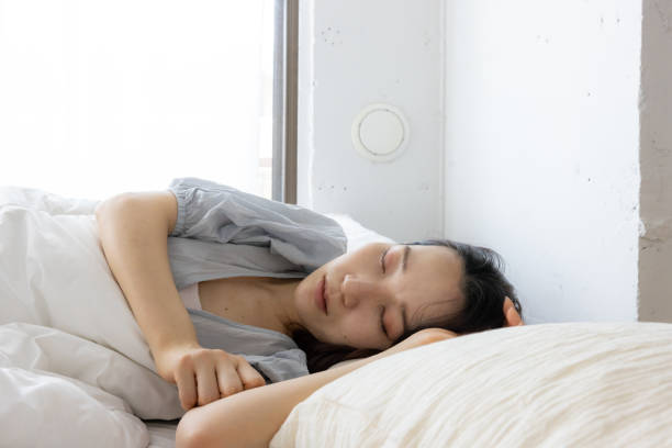 istock Young woman sleeping on bed in the morning 1473071796