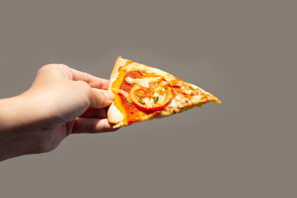 istock Hand hold pizza cut in slices 1473072929