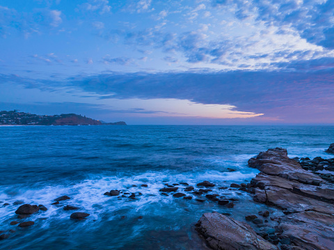 Sunrise seascape with clouds,  surf and atmosphere at Avoca Beach on the Central Coast, NSW, Australia.