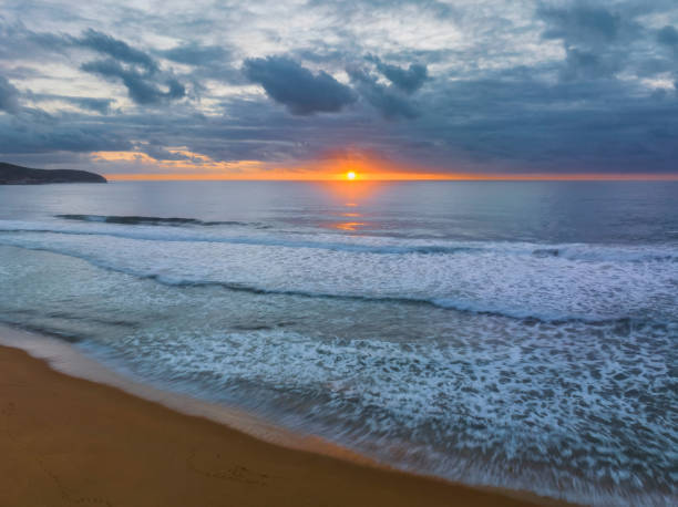 istock Soft sunrise seascape with clouds and sun on the horizon 1473075002
