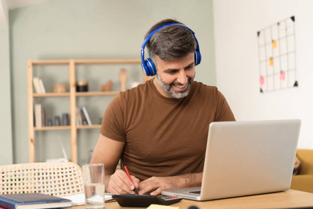 istock Man studying online at his home office 1473075303