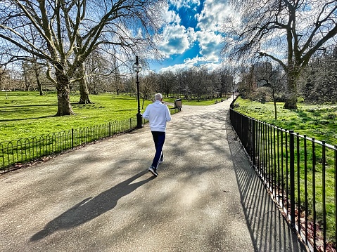 London, United Kingdom - March 07 2022: a senior citizen is jogging on a sunny day in the british capital in hyde park