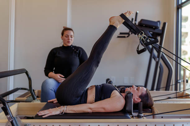istock Fit woman using pilates machine during physical therapy appointment 1473075801