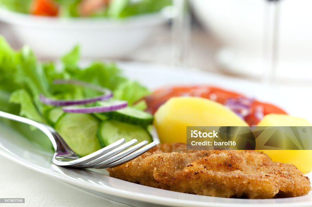 Escalope de veau panée avec des pommes de terre et salade - Photo de Aliment libre de droits