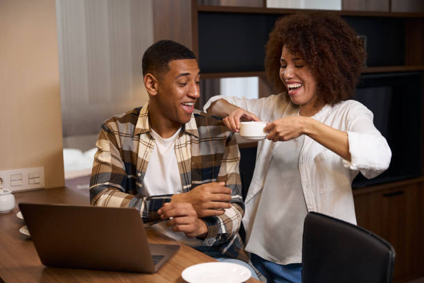 istock Guy with laptop sits at table in the kitchen area 1473077873