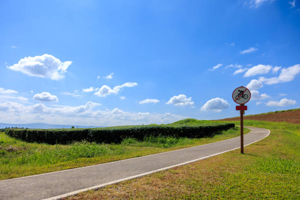 pas de vélo passant sur cette route dans le parc et fond ciel bleu, - no passing lane photos et images de collection