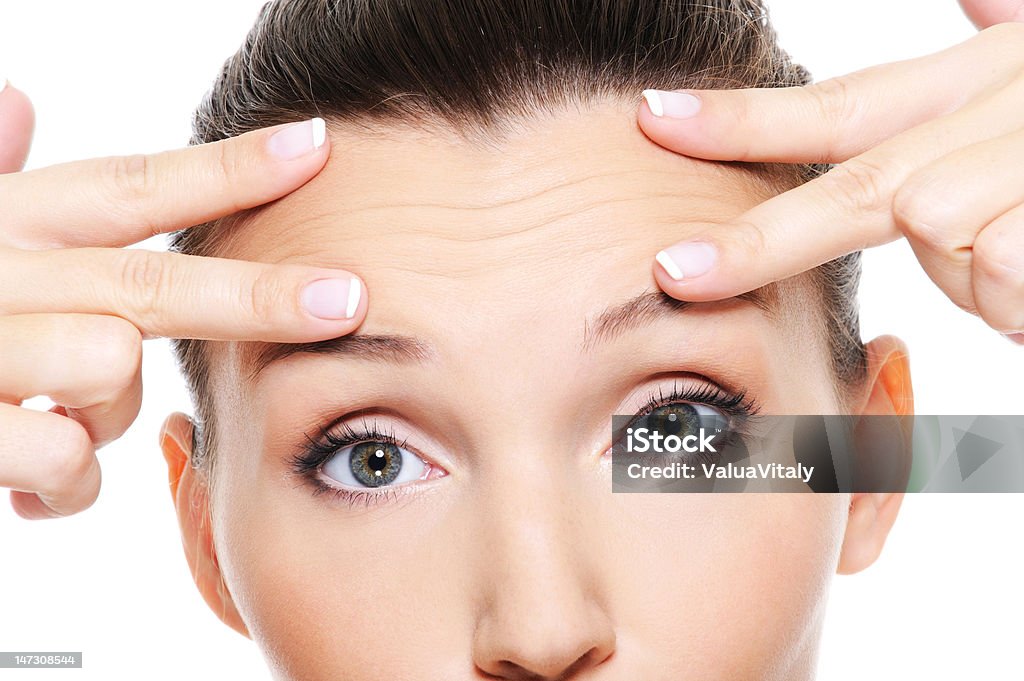 Young woman's face showing wrinkles on forehead Female face with wrinkles on forehead - skincare treatment Wrinkled Stock Photo