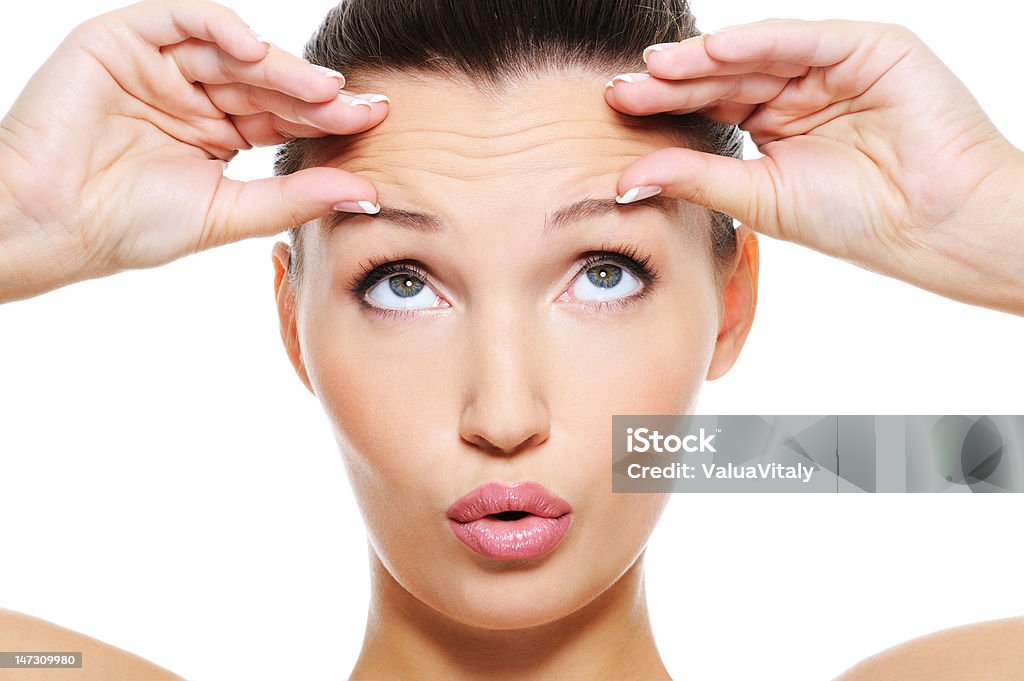 female face with wrinkles on her forehead Close-up female face with a big wrinkles on her forehead - isolated on white Wrinkled Stock Photo