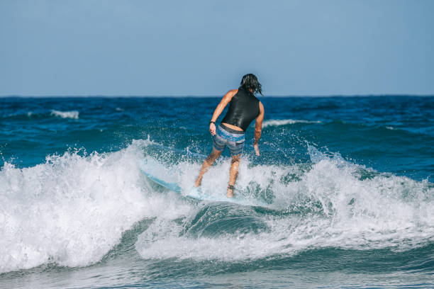istock Asian Chinese Male Surfer riding wave in Pacific Ocean 1473107459