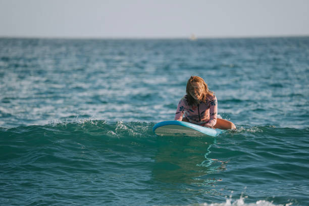 Excited female chinese surfer learning surfing in Kenting Beach during sunset