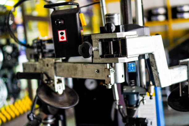 istock Image showing mechanical arm equipment that uses motor and electric systems for rotating wheels in the car repair shop and changing tires. 1473110157