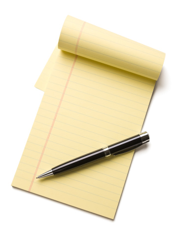 Pen laying on a blank note pad with copy space.