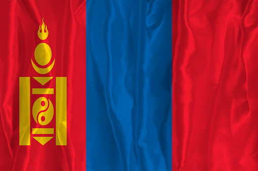 The flag of Mongolia on a silk background is a great national symbol. Texture of fabrics The official state symbol of the country