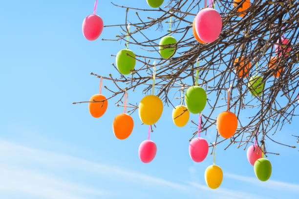 Multi-colored Easter eggs against the background of a light blue sky, horizontal format