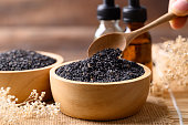 Black sesame seed and oil on wooden background, Food ingredients in Asian cuisine