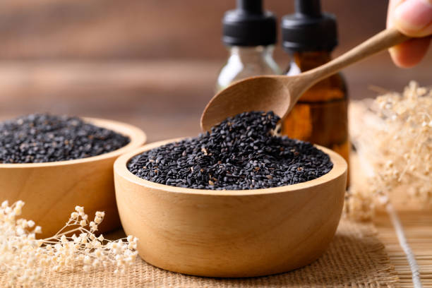 Black sesame seed and oil on wooden background, Food ingredients in Asian cuisine stock photo