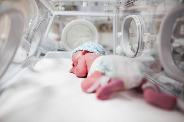 Newborn baby boy covered in vertix inside incubator Newborn baby boy covered in vertix inside incubator incubator stock pictures, royalty-free photos & images