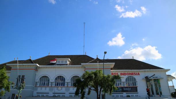 Low angle view front exterior of Kantor Pos Indonesia or Post Office Building. Clear blue sky. Signboard Name. Yogyakarta, December 17th, 2022. Low angle view front exterior of Kantor Pos Indonesia or Post Office Building. Clear blue sky. Signboard Name. kantor stock pictures, royalty-free photos & images