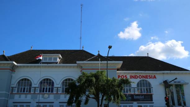 Low angle view front exterior of Kantor Pos Indonesia or Post Office Building. Yogyakarta, December 17th, 2022. Low angle view front exterior of Kantor Pos Indonesia or Post Office Building. Clear blue sky. Signboard Name. kantor stock pictures, royalty-free photos & images