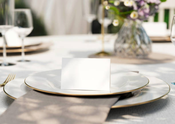 istock Mockup white blank space card, for Name place, Folded, greeting, invitation on wedding table setting background. with clipping path. 1473130353