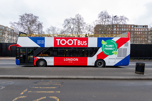 A Double-Decker bus stands in South Kensington, London, England, UK on a cloudy day.