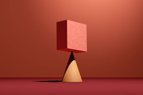 A pink cube block is balancing on a cone. Concept of balance, harmony or stability.