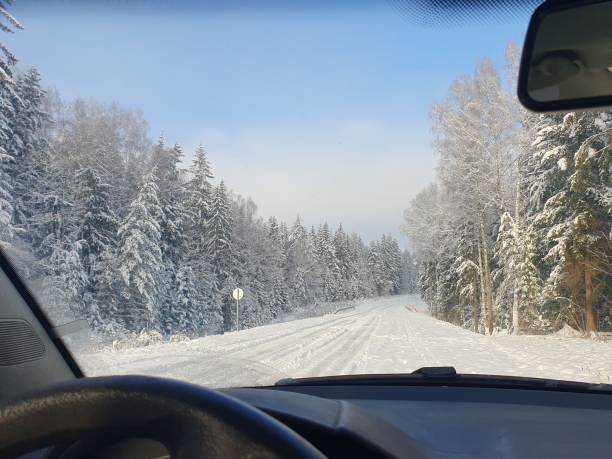 istock Automobile road through winter forest covered with snow 1473137274