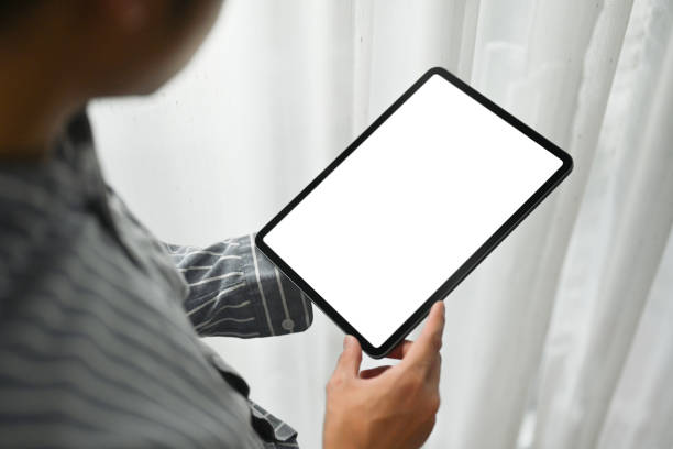istock Over shoulder view of businessman hands holding digital tablet. White empty screen and blank space for your text. 1473137932